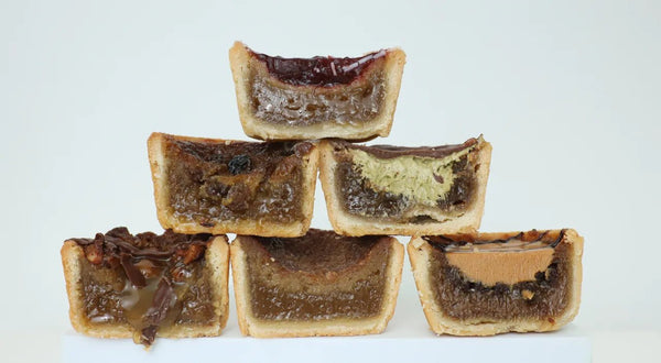 Butter tart on a flaky pastry shell with a glossy, syrupy filling, possibly with raisins and a hint of caramel