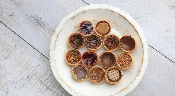 assorted butter tarts in gift boxes on a wooden table, with festive packaging and a Canadian theme for gifting occasions