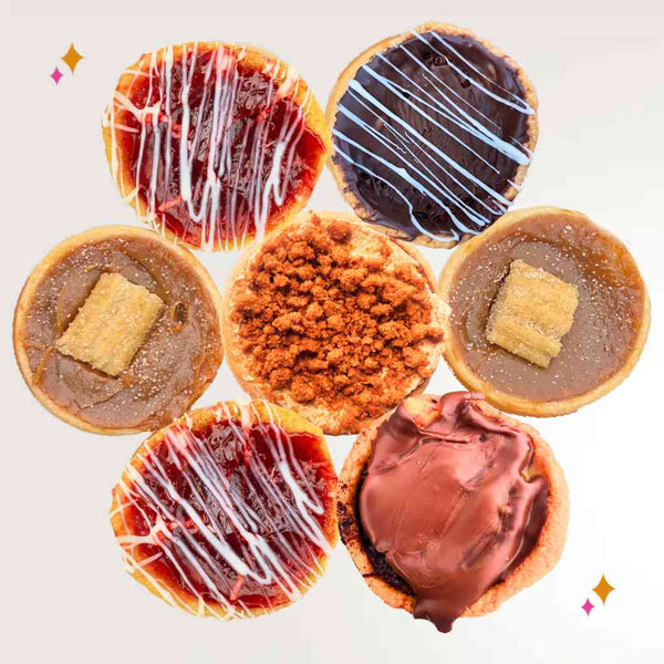 cluster of butter tarts with glossy centers, berries and citrus accents in a summer-inspired assortment