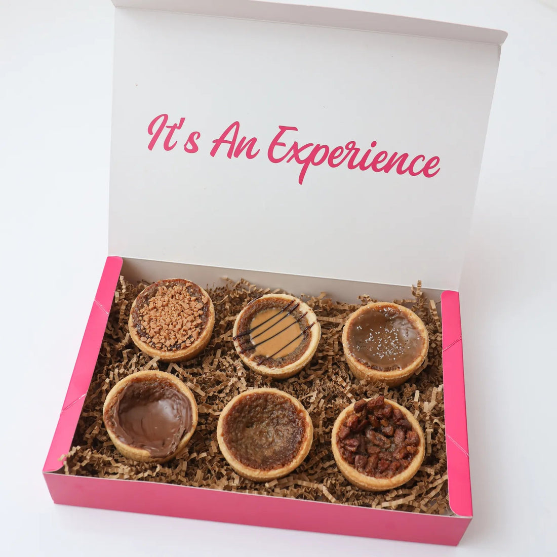 A colorful assortment of Toronto dessert gift boxes with assorted cookies, tarts, truffles and small cakes arranged in a gift-ready display