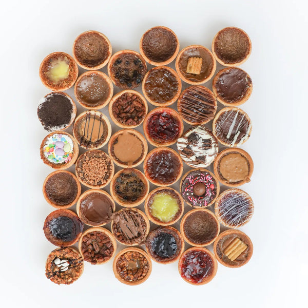 award-winning butter tarts on a plate with caramelized tops and flaky pastry, close-up highlighting glossy filling and golden textures